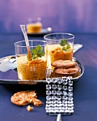 Zwei Gläser Curry-Linsensuppe auf einem Tablett mit vier Keksen