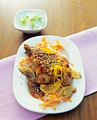 Turkey leg with rice, onions and orange sauce on plate