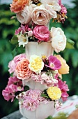Rosenblüten in einer Vase auf drei verschiedene Ebenen verteilt