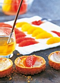 Grapefruit und Orangen, Scheibchen werden auf den Mürbeteig gelegt