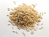 A pile of raw rice on white surface