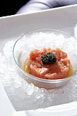Close-up of tuna tartar with caviar in glass bowl on ice