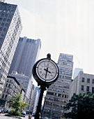 Clock in square outside Tribeca Grand Hotel with skyscrapers in background