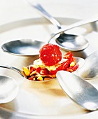 A tomato tartlet served on a spoon