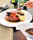 Close up of English roast with mashed potatoes and cherry tomatoes on plate