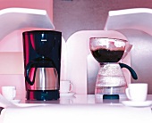 Coffee maker, jug and white coffee cups