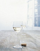 Glas mit Weißwein und ein Korken 