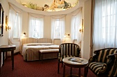 Bedroom with bed, curtains and chairs in hotel, Germany