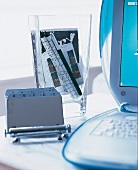 Adressenkartei, dahinter Glas mit Büroartikeln, am Bildrand ein iBook
