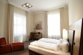 Bedroom with bed, curtains and chairs in hotel, Germany