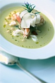 Close-up of chickpea soup with rosemary, cray fish and lardo in bowl