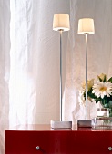 weiße Tischleuchten mit poliertem Edelstahlfuß und Porzellanschirmen