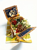 Picnic basket made of woven willow with various food in it
