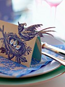 Place card with bird motif on plate