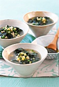 Italian minestrone with zucchini, peas, spinach and pesto garlic in bowl