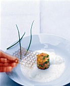 Fish tartare with lattice being held on plate