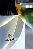 Glas Weißwein mit dem Firmenlogo von Weigut Loimer