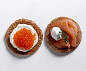 Blinis with smoked salmon, salmon caviar and sour cream on white background