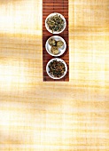 Three types of green tea on small white plates, overhead view