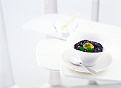 Polenta with foie gras, quail egg and black truffles in bowl