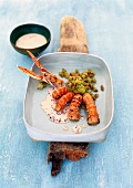 Langoustines with eggplant, olives and fennel cream in serving dish