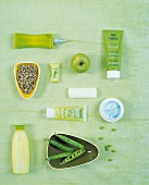 Verschieden Kosmetikprodukte auf grünem Untergrund.