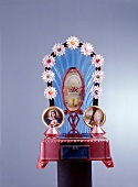 Pink altar with holy images and candle stands against grey background