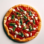 Pizza topped with green chillies and sage on white background