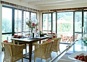 View of terrace garden from kitchen with wicker furniture