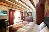 Bedroom with bed, cushion, chairs and table in hotel, Germany