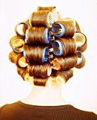 Close-up of blonde woman's head with many curlers in her hair