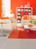 Wohnzimmer mit hellem Sessel und Sofa, Wand + Teppich orange