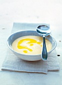 Drizzled cream soup with white beans and olive oil in bowl