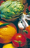 Close-up of various foods like orange, artichoke, mushrooms and tomato