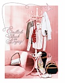 Business clothes hanging on clothes rack and hand bag on floor in pink room