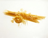 Raw pasta, spaghetti and butterfly noodles on white background