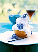 Close-up of peach with meringues decorated with violets on plate