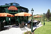 People seated under shades outside restaurant