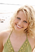 Berit,  Frau mit grünem Sonnentop am Strand, lacht in die Kamera