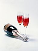 liegende Flasche Champagner Krug Rosé, daneben zwei gefüllte Gläser