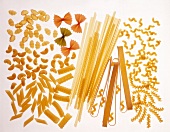 Various pastas on white background, overhead view