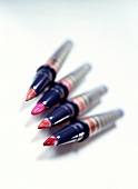 Four lip brush with various shades over bristles on white background