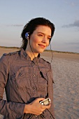 Janine Frau hört am Strand Musik