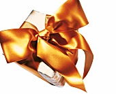 Gift wrapped with yellowish orange Saturn ribbon on white background