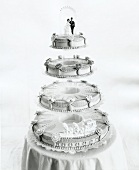 White wedding cake with four layers at top bridal couple figurine, black and white