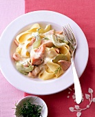 Pasta with salmon and cucumber sauce on plate