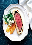 Roasted beef with potato chips, tartar sauce and watercress leaves on plate