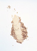 Close-up of loose powder of eye shadow on white background, overhead view
