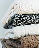 Stack of four woollen sweaters