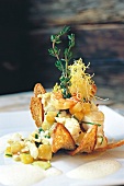 Close-up of fish hash with bread hood, garnished with fennel foam